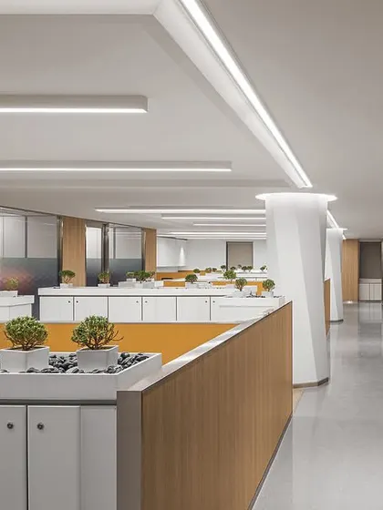 A view of the open-plan workstation area in 'The Layered Office'. We clad large structural columns in Corian with a twisted hexagonal design and integrated planters into the storage units to add visual interest and greenery.