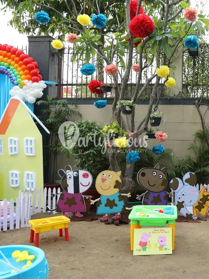 A playful scene from the Peppa Pig party, with characters in muddy puddles and a colorful house backdrop.