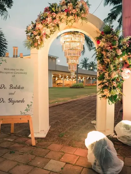 A chic welcome sign and floral arch at the entrance to a reception, setting a sophisticated tone.