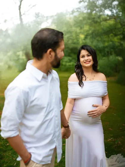 A candid shot of the couple sharing a smile. These unposed moments often make for the most cherished memories from a couple's maternity photoshoot.