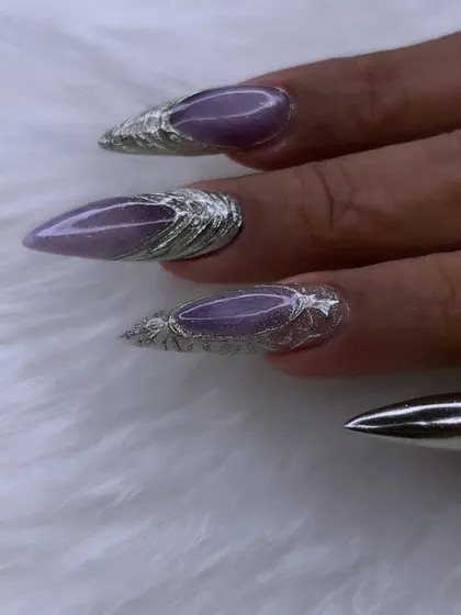 A close-up of the intricate 3D silver chrome work on these stiletto nails. The texture and shine create a liquid metal effect that is truly stunning.