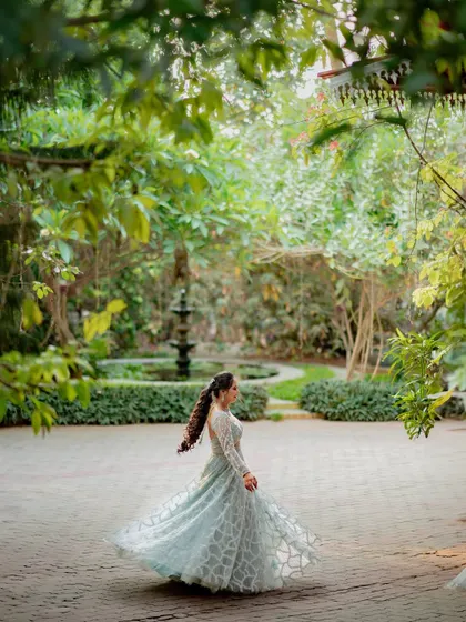 A beautiful shot of the bride, Lavanya, twirling in her gown in the gardens of the reception venue.