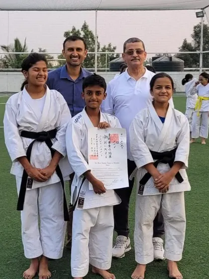 A student, joined by his proud family and Sensei, holds his official WSKF black belt certificate. We believe karate is a journey the whole family can be proud of.