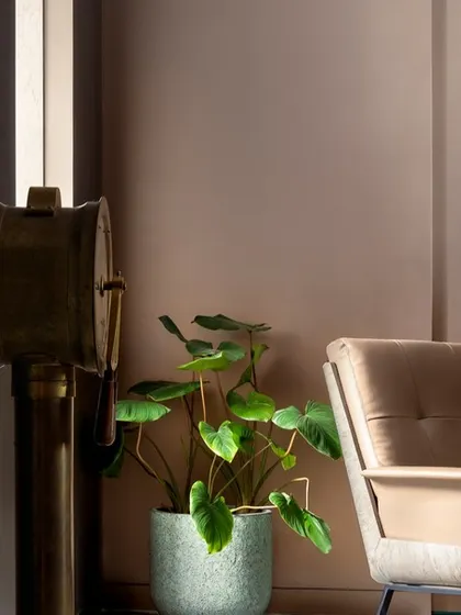 A detail shot of the reading corner in the teal bedroom. The plush armchair, warm lamplight, and curated decor create a perfect spot for quiet contemplation.