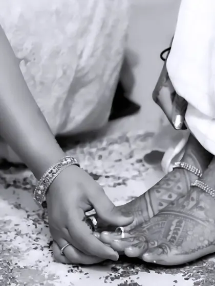 A beautiful black and white shot focusing on the details of a wedding ritual. This image highlights the bride's henna-adorned feet and the traditional toe rings, symbolizing a new beginning.