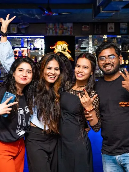 A group of friends ready to party, posing with rock-on signs. The energy is always high, especially on weekends.