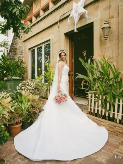 A beautiful, full-length portrait of the bride in her stunning gown. The natural setting and the elegant train of the dress create a timeless and romantic image.