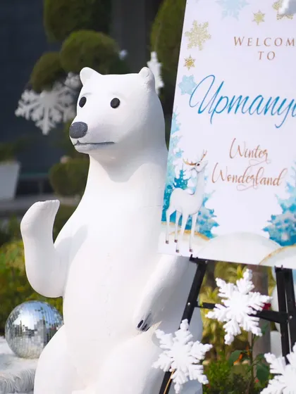 A friendly polar bear prop stands next to the welcome sign for "Upamanyu's Winter Wonderland," greeting guests as they arrive.