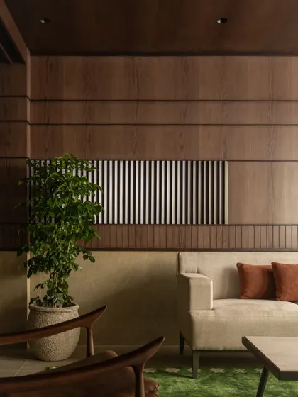 A quiet corner in the VIP lounge, showcasing the rich textures of the wood-paneled walls, comfortable seating, and a touch of greenery. It’s a space designed for calm conversation.