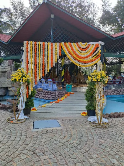 An entrance to a poolside venue decorated with marigold garlands for a traditional touch.