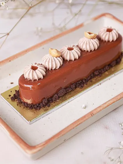 An elegant Hazelnut Caramel Entremet, combining rich hazelnut flavors with luscious caramel in a sophisticated French-style pastry.