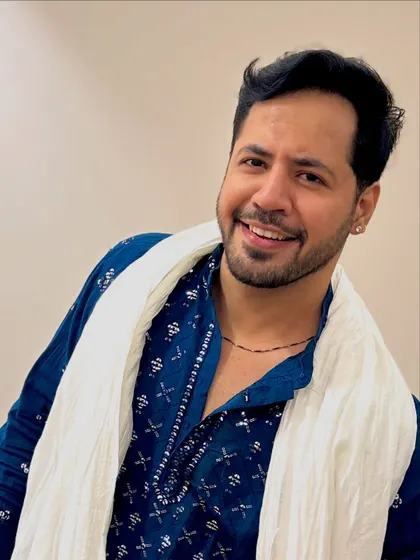 A close-up portrait in the blue kurta, with a friendly and engaging smile. I connect with the camera just like I connect with the audience.
