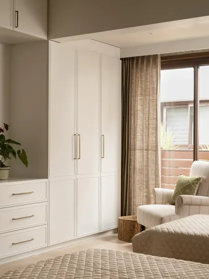 Even in guest rooms, we prioritize functional storage. These clean-lined white wardrobes provide ample space while keeping the room feeling bright and airy.
