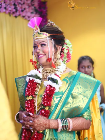 Our bride during her wedding ceremony, looking absolutely radiant. The traditional headwear and garlands are complemented by our flawless makeup application.