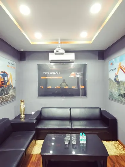 A comfortable client lounge or closing room with plush leather sofas and branded graphics. This space provides a private and relaxed setting for finalizing business.