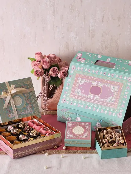 Our Sparkle & Sweets hamper is a beautiful gift set containing rose petal cashews, mini brownie bites, and a box of 16 assorted sugar-free mithai.