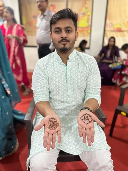 Mehendi for the groom. A simple design with the couple's initials and a portrait of his bride. Grooms deserve some henna love too.