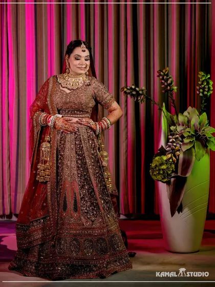 A full-length portrait of the bride in her bridal lehenga, posing with confidence and grace.
