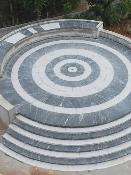 The completed amphitheater at 'The Sanctuary', featuring a striking concentric circle pattern in black and white stone, serves as a functional gathering space and a graphic focal point.
