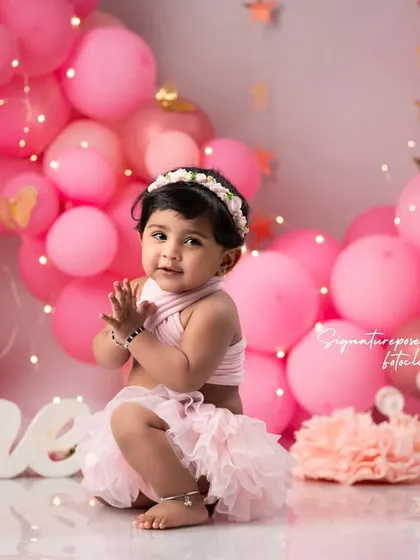 Another delightful moment from the same pink-themed first birthday shoot, showing the little one clapping her hands in excitement.