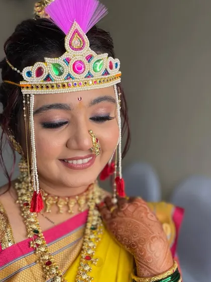 A close-up of the bride's happy face, adorned with the traditional Bashing, ready for her wedding rituals.
