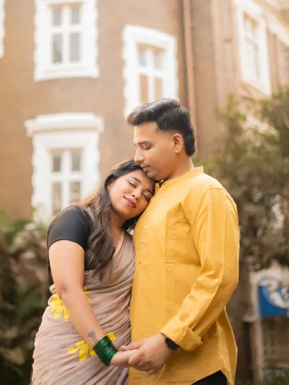 A serene pre-wedding portrait of a couple in a quiet embrace. The bride-to-be rests her head on her partner's shoulder, creating a moment of peaceful connection.