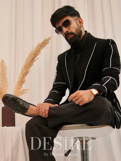 A confident pose in the black blazer with white piping. This piece is perfect for creating a sharp, modern look that is both timeless and versatile.