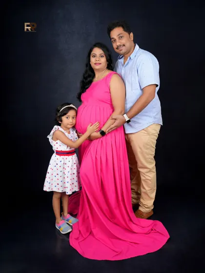 A complete family portrait. The mom-to-be, her partner, and their daughter all together, creating a beautiful memory before the new baby arrives.