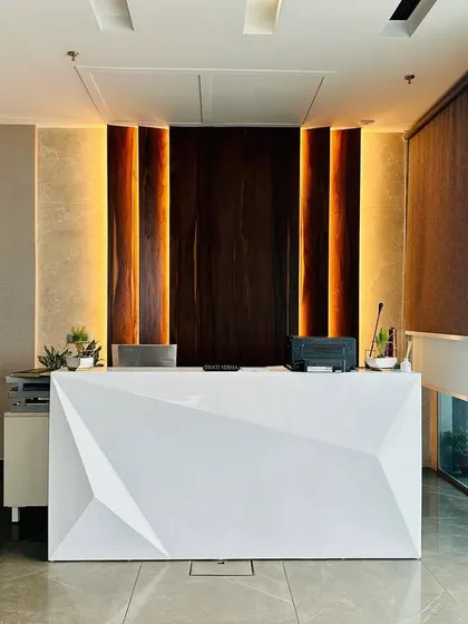 A balanced, symmetrical view of the reception area, emphasizing the clean lines and the powerful visual impact of the central desk and feature wall.