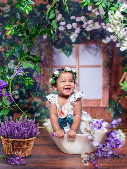 A baby's infectious laughter captured in a beautiful garden-themed bath shoot. The lavender flowers and her joyful expression create a truly heartwarming photo.