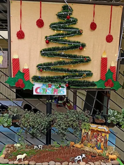 A complete Christmas decoration setup, with a wall-hanging tree and a nativity scene (crib).