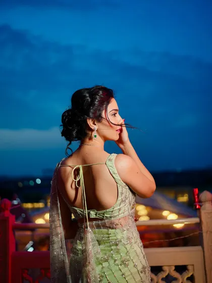 Another angle showing the backless design of the blouse and the beautiful drape of the saree against the twilight sky.