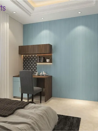 A calm and serene bedroom with a blue fluted accent wall and a compact wooden study desk.