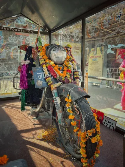 Another angle of the worshipped Royal Enfield motorcycle, encased in glass at the unique Bullet Baba Temple.
