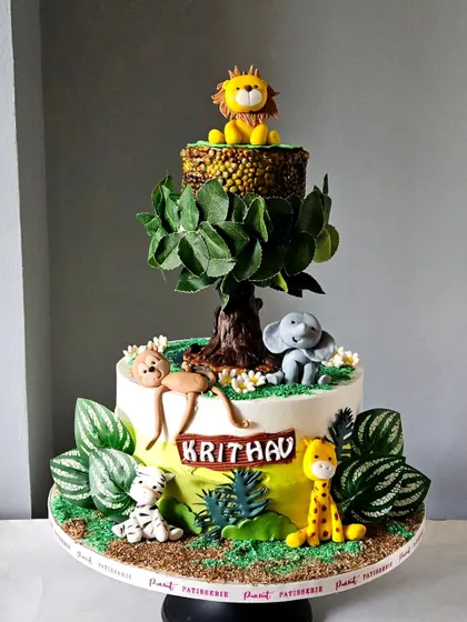 The full view of the impressive revolving jungle tree cake, showcasing its unique structure and detailed animal figures.