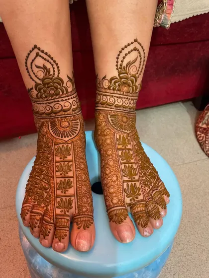 A beautiful foot design with a focus on lotus motifs, covering the entire foot in a dense and traditional pattern.