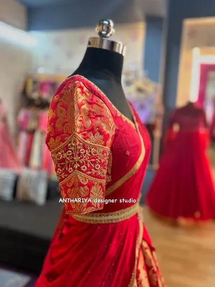 A close-up of the puff sleeves with gold embroidery on the red lehenga.