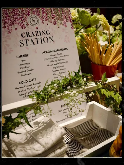 The full grazing station setup, complete with fresh flowers, breadsticks, and neatly arranged napkins and cutlery.