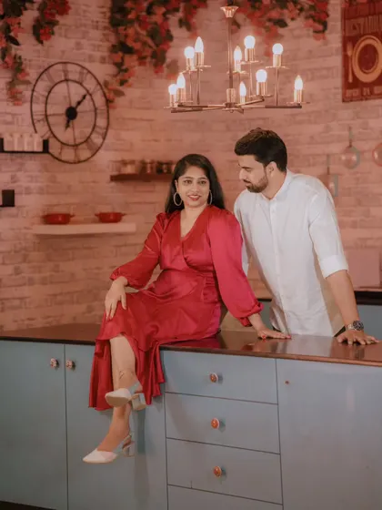 A cozy and stylish shot in our modern kitchen set. The bride's satin dress and the warm lighting create an intimate and chic pre-wedding photo.