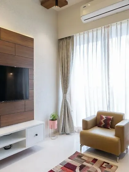 This living room TV unit features a simple yet elegant design with a wooden back panel and a floating white console. The side-lit panel adds a soft glow, making the space feel warm and inviting.