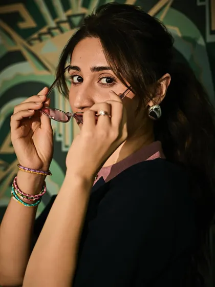 A fun, candid moment that shows off the playful accessories we chose for this look. The colorful bracelets add to the youthful vibe.