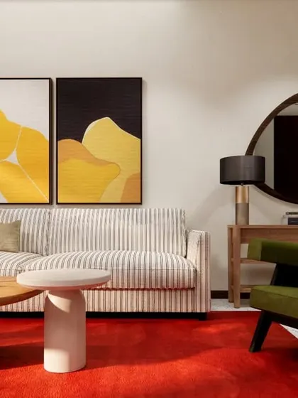 Another view of the HAUS 5 living room, showcasing the balance of bold color in the rug and artwork with the neutral tones of the walls and sofa.