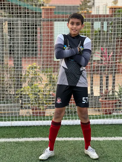 A young goalkeeper stands confidently in front of the net. We build not just skills, but also the self-assurance needed to command the goal area.