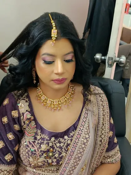 Our artists pay close attention to every detail. This image shows the final touches on a client's hair and makeup, ensuring every strand is in place and the makeup is blended seamlessly for a picture-perfect result.