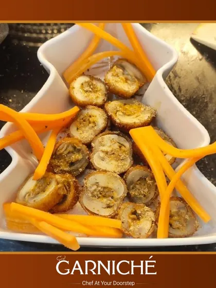 An example of our creative appetizers. These are savory mushroom rolls, sliced and served with fresh carrot sticks for a delightful crunch.