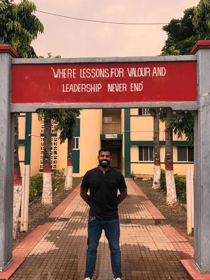 Standing at the entrance of my school, under the sign: "Where lessons for valour and leadership never end."