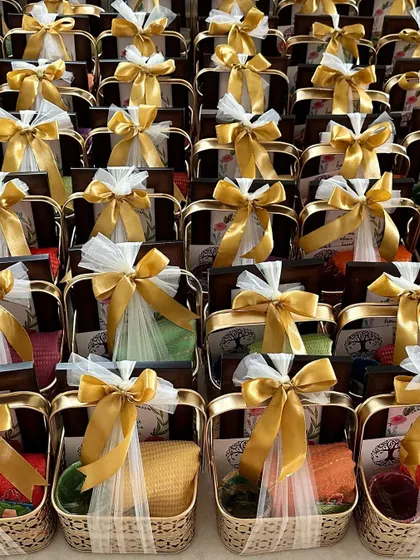 A large order of housewarming favors, each elegantly wrapped in white tulle and tied with a gold ribbon.