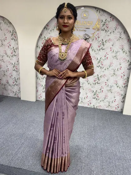 A complete look featuring a lovely lavender silk saree. The makeup is kept soft and elegant to complement the color of the outfit and the traditional gold jewellery.