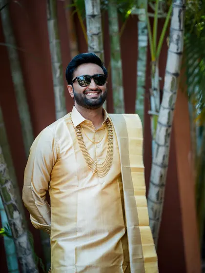 A handsome portrait of the groom in his traditional silk attire, smiling confidently.