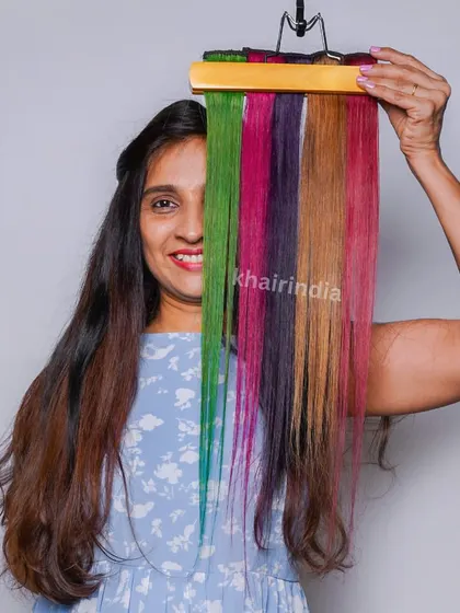 A client playfully peeks through a rainbow of our color bands. It shows the variety of fun and vibrant options available to express your personality.